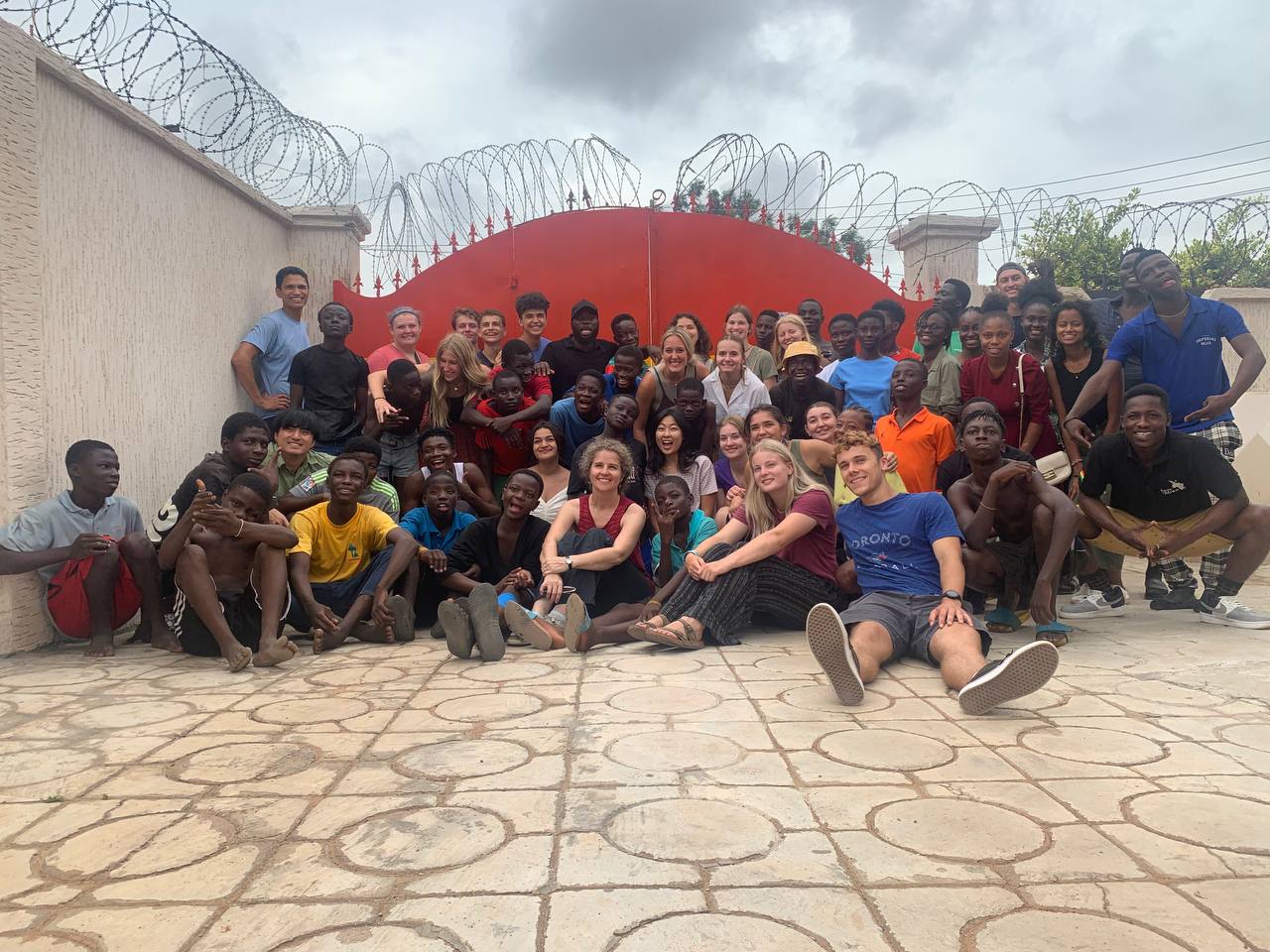 Future of Africa Staff and Youth in Front of Painted Gate